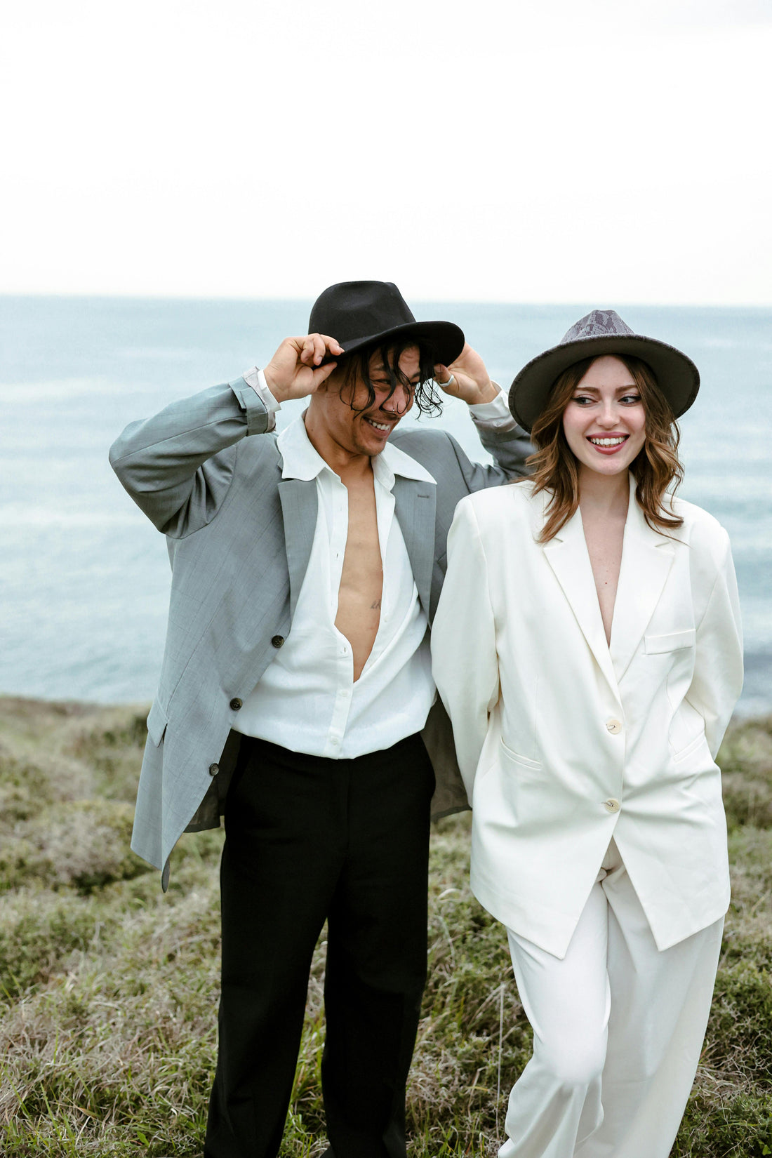 man and woman walking near ocean