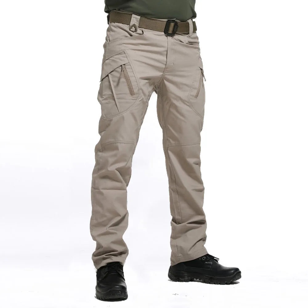 Beige tactical pants with multiple pockets and a belt on a white background