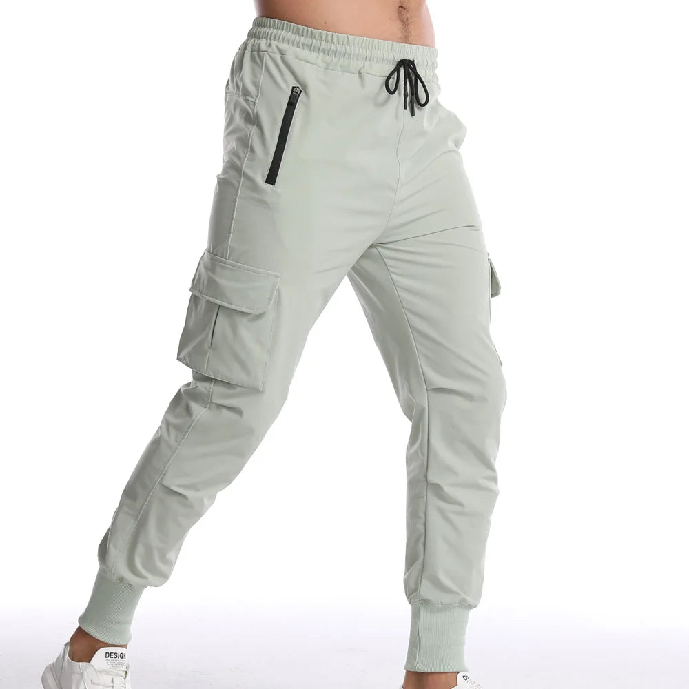 Men's cargo style sports pants in light green with adjustable drawstring and side pockets for peak performance.