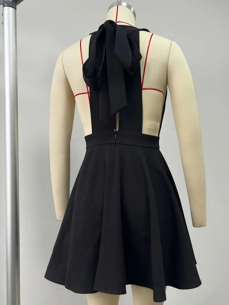 Back view of a black halter dress featuring a bow tie detail and a stylish A-line skirt.
