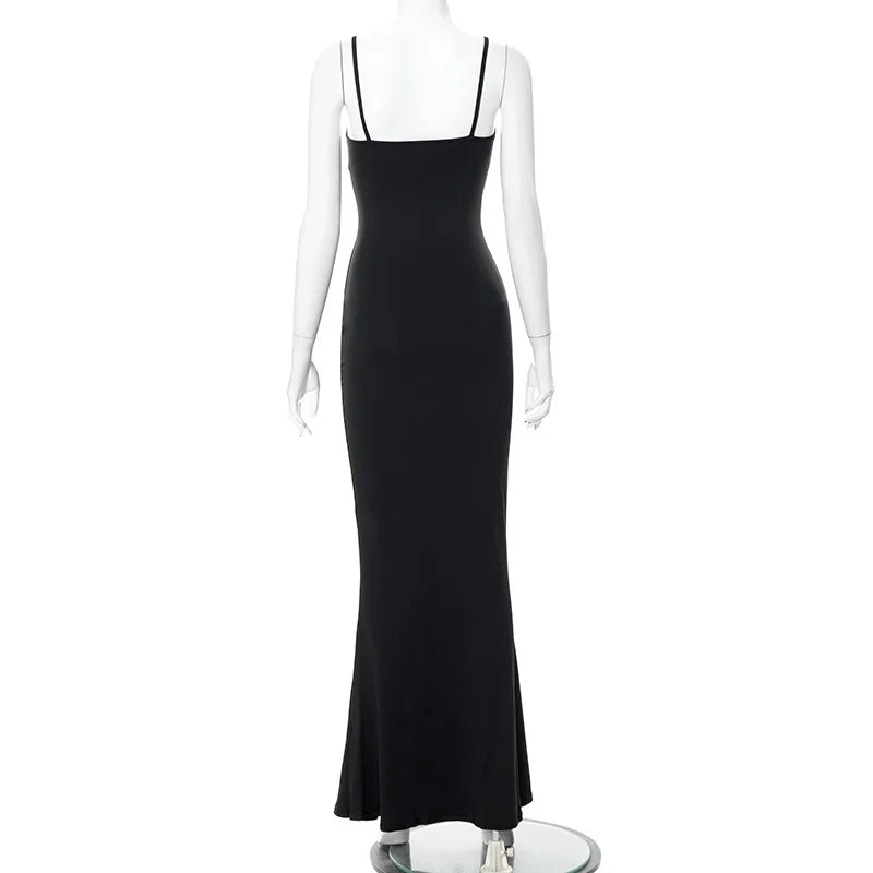 Back view of a sleek ankle-length black slip dress with spaghetti straps and a trumpet silhouette.