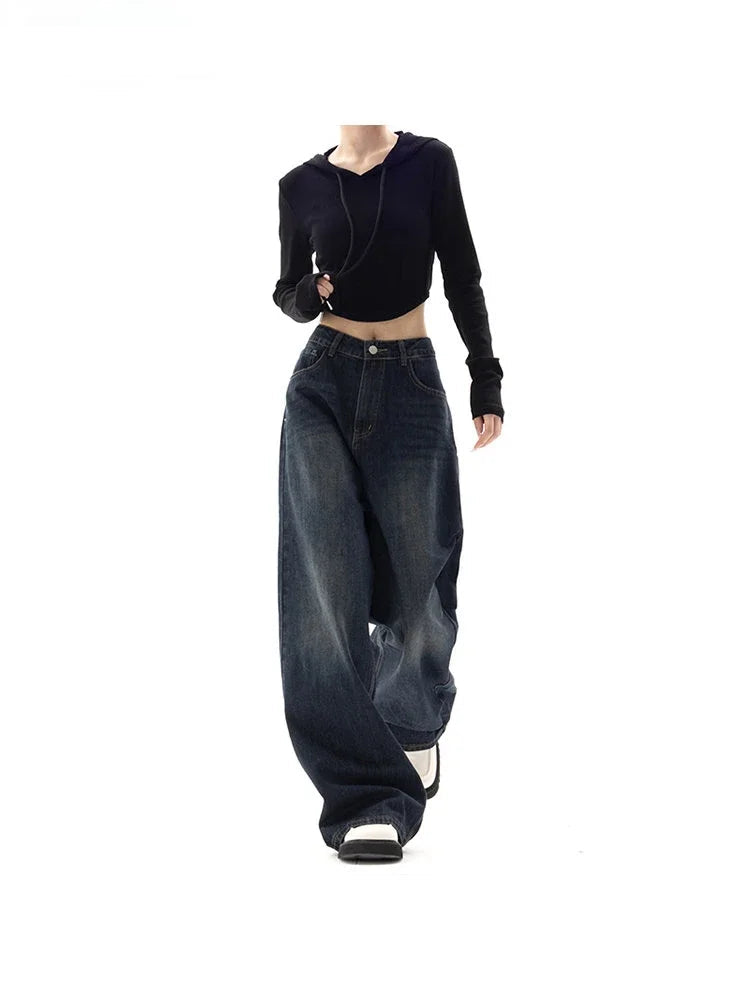 Person wearing a black crop top and wide-leg jeans on a white background