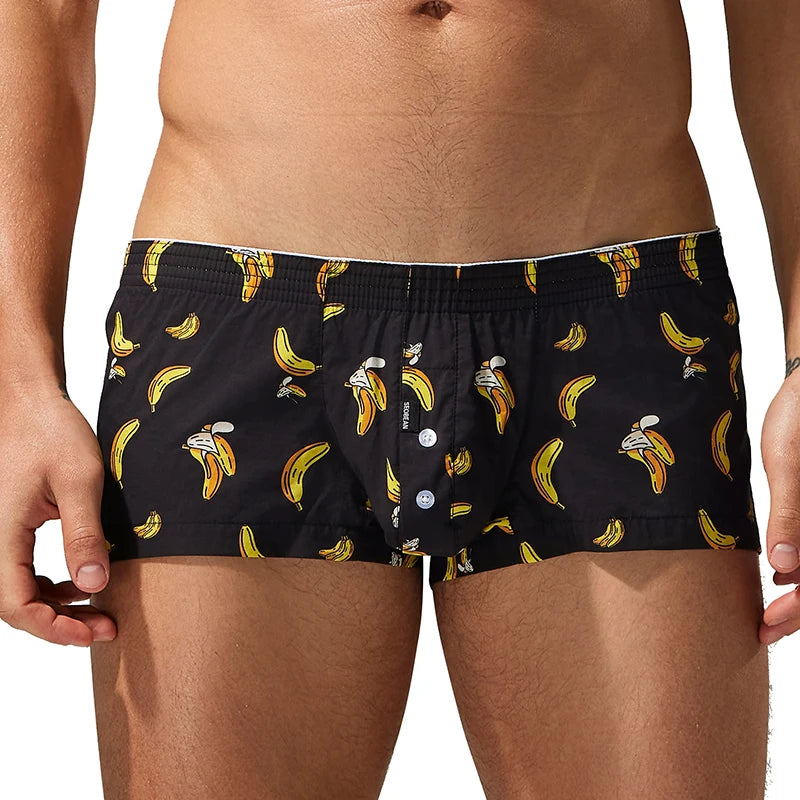 A close-up of a man wearing black boxer briefs with a yellow banana and white cartoon bee print, shown from the waist to upper thighs against a white background.