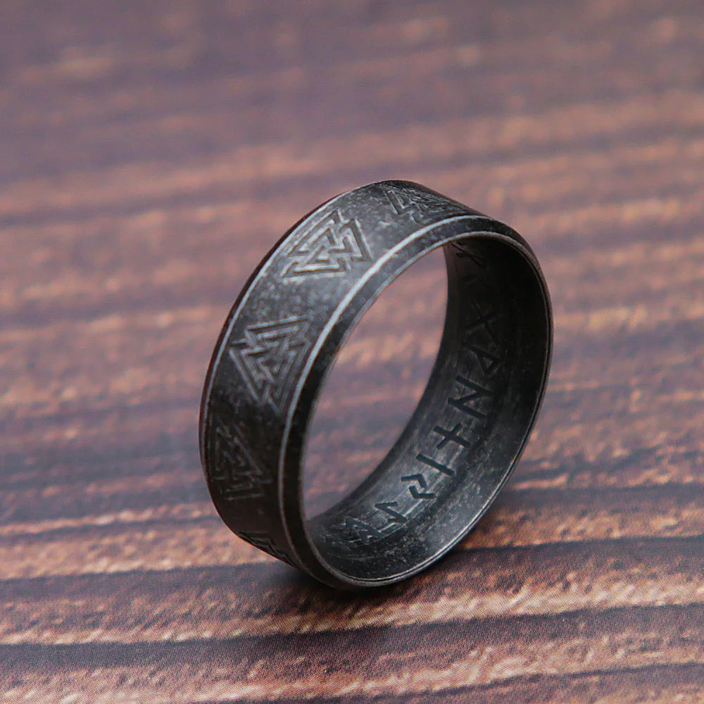 Black engraved ring on a wooden surface