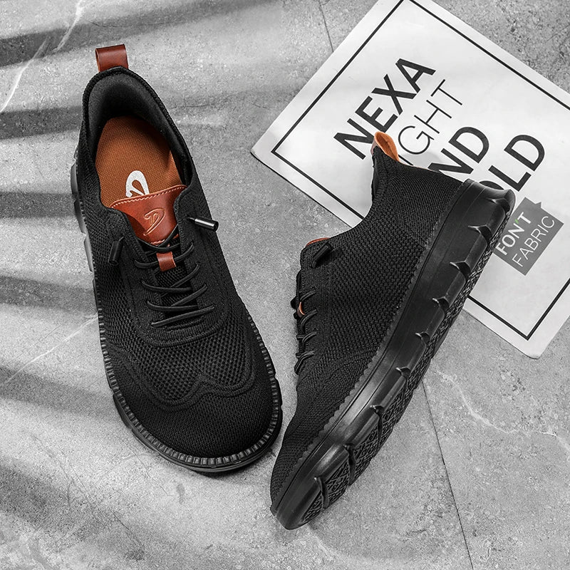 Black athletic shoes on a gray surface with a brand label in the background.