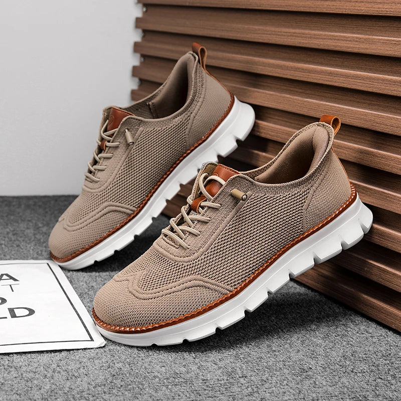 Beige sneakers with white soles on a gray surface with wooden slats in the background