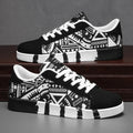 Black and white patterned sneakers on a wooden surface with a gray background