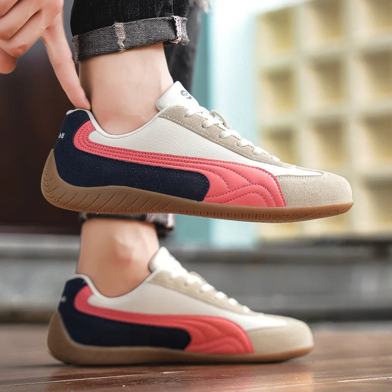 Person wearing a beige and red sneaker with a blurred background