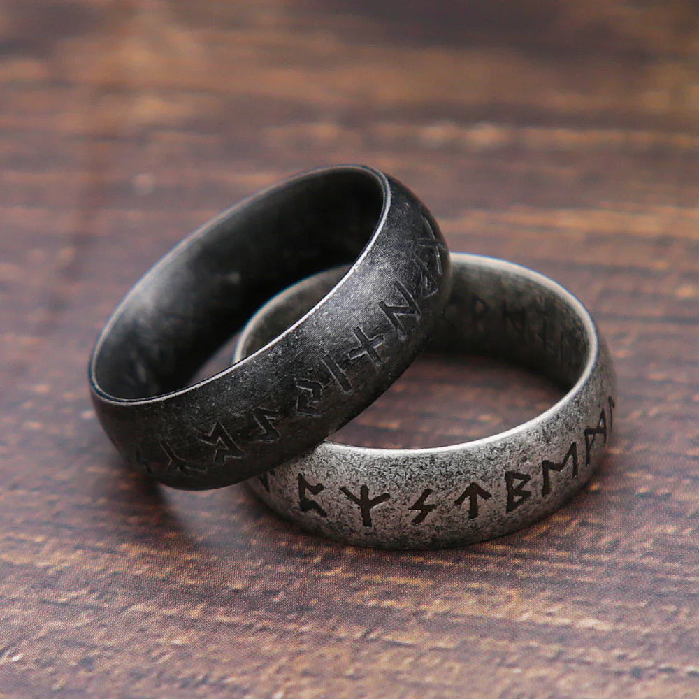 Two rings with engraved symbols on a wooden surface