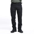 Black tactical pants worn by a person on a white background