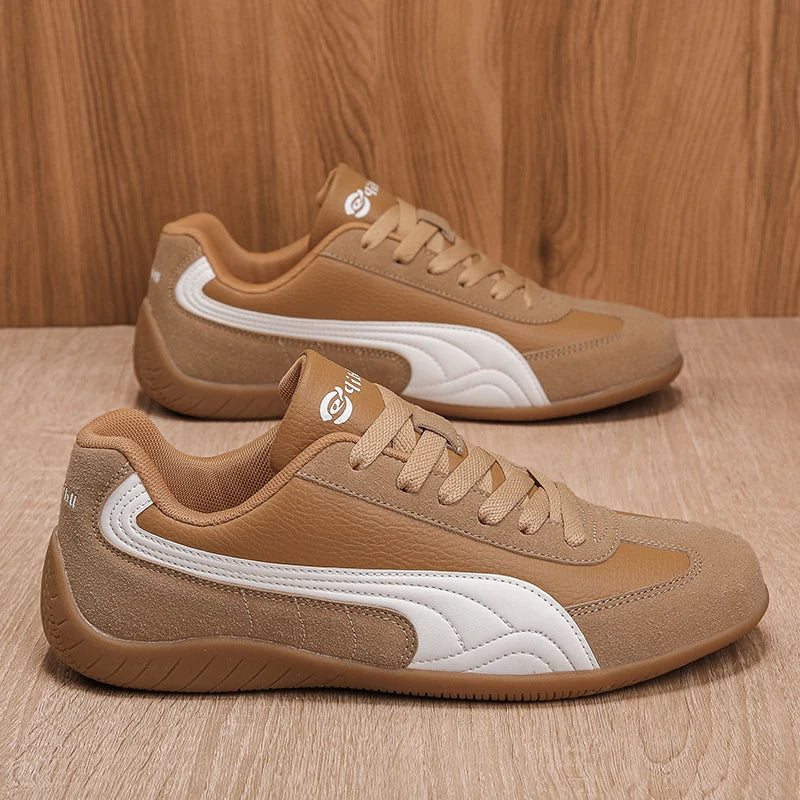 Brown sneakers with white accents on a wooden surface