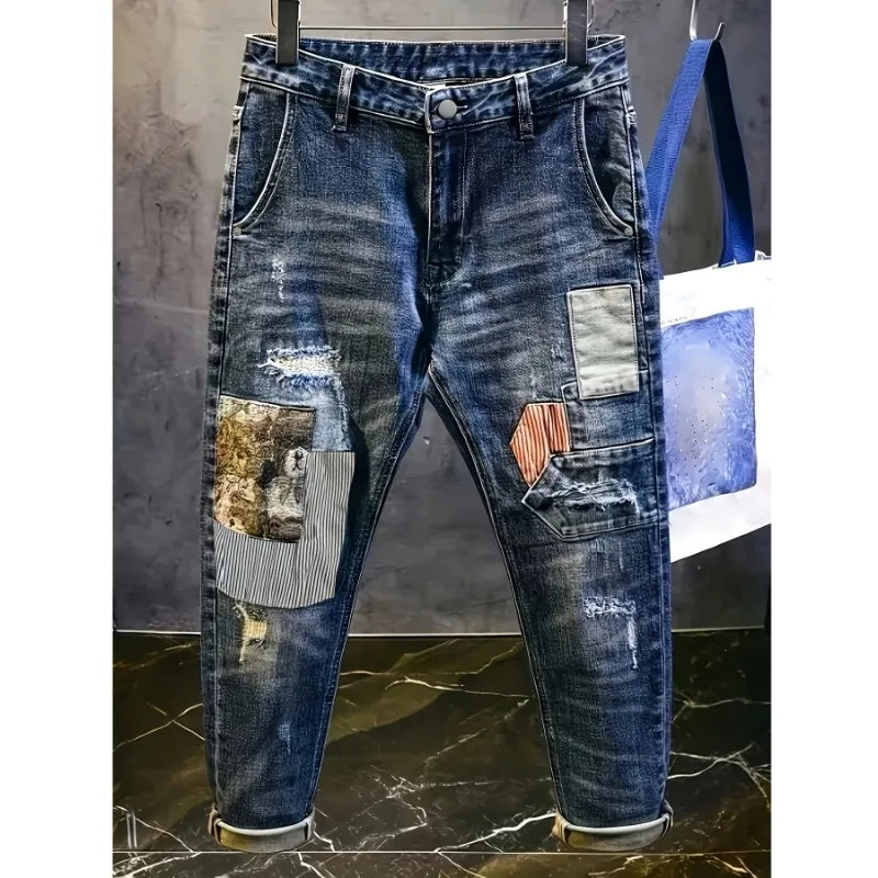 Distressed blue jeans with patchwork design on a marble floor.
