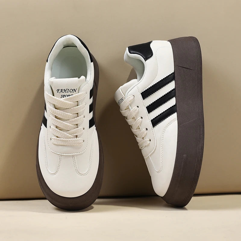 White sneakers with black stripes and brown soles on a beige background